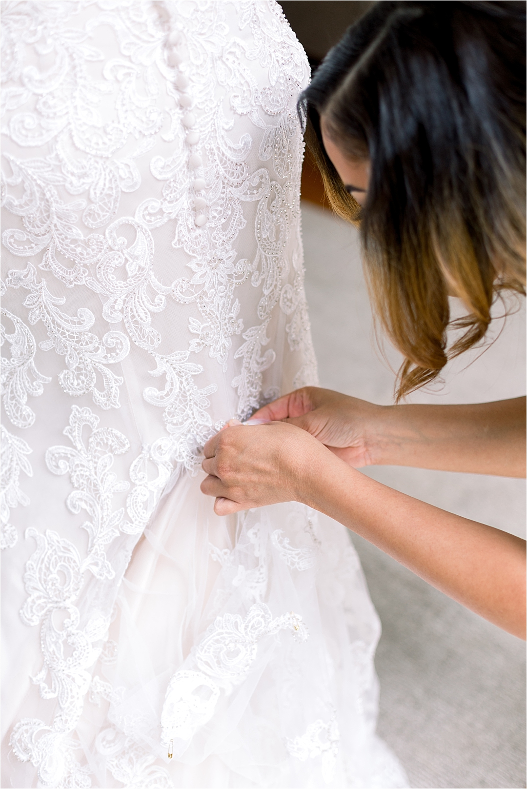 maid of honor helping bride with buttons on lace wedding dress_Photos by Leigh Wolfe, Atlanta's Top Wedding Photographer