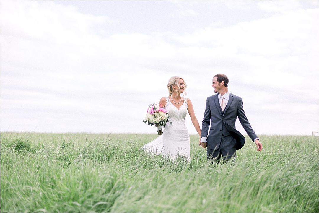 bride and couple walking through field_Photos by Leigh Wolfe, Atlanta's Top Wedding Photographer