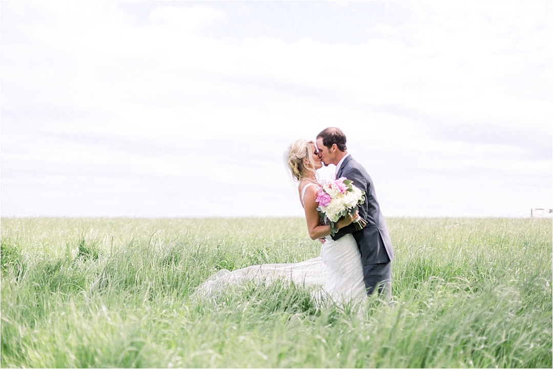 Bride and groom kissing in field of hay_Photos by Leigh Wolfe, Atlanta's Top Wedding Photographer