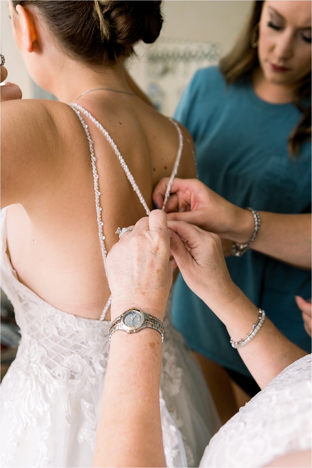 bride getting helped into wedding dress_Photos by Leigh Wolfe, Atlanta's Top Wedding Photographer