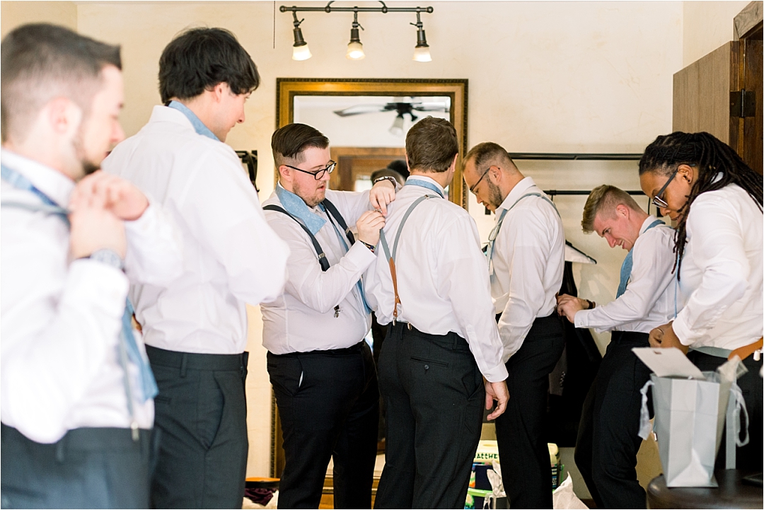 groom helping groomsmen get dressed_Photos by Leigh Wolfe, Atlanta's Top Wedding Photographer