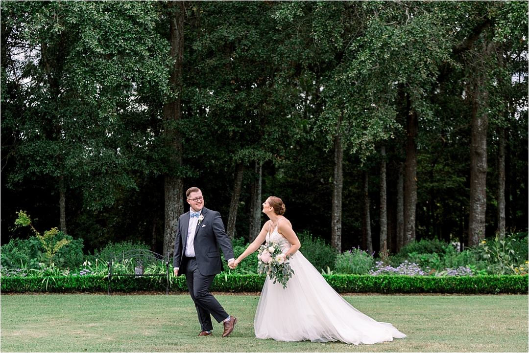 bride and groom walking through garden_Photos by Leigh Wolfe, Atlanta's Top Wedding Photographer