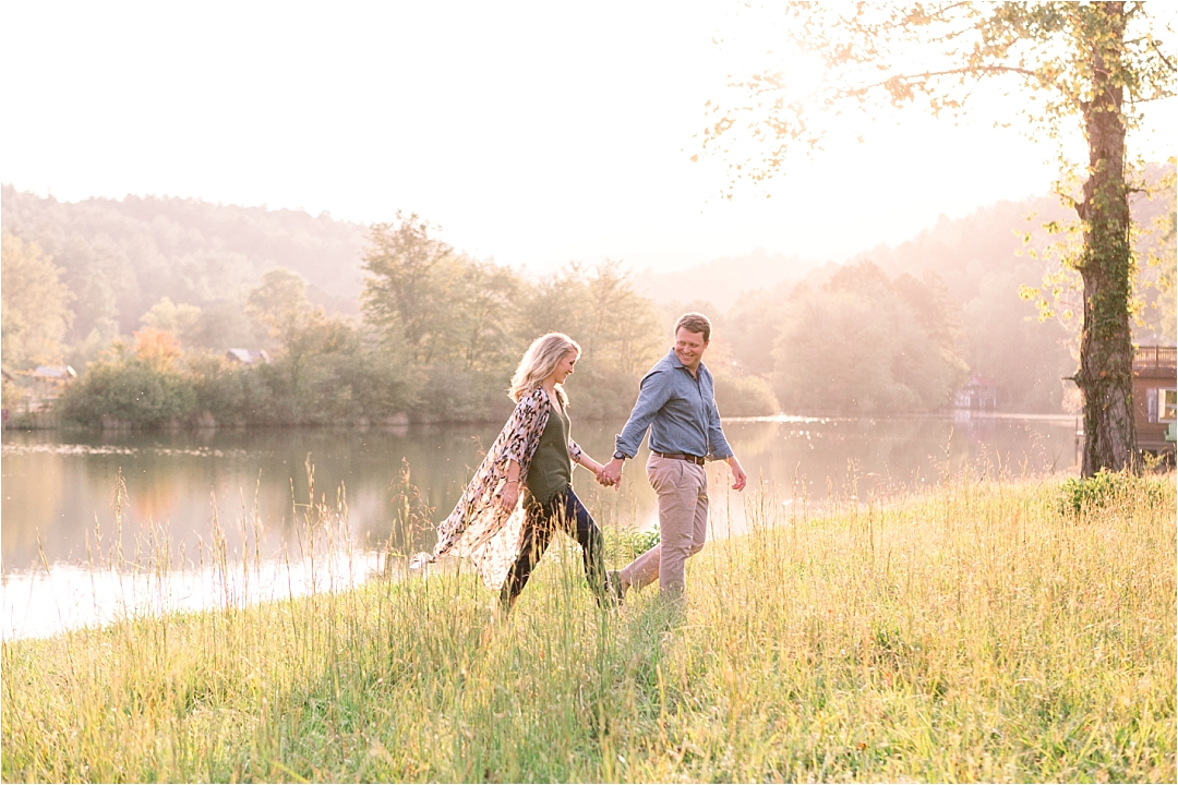 couple running through tall grass by lake at golden hour_Photos by Leigh Wolfe, Atlanta's Top Wedding Photographer