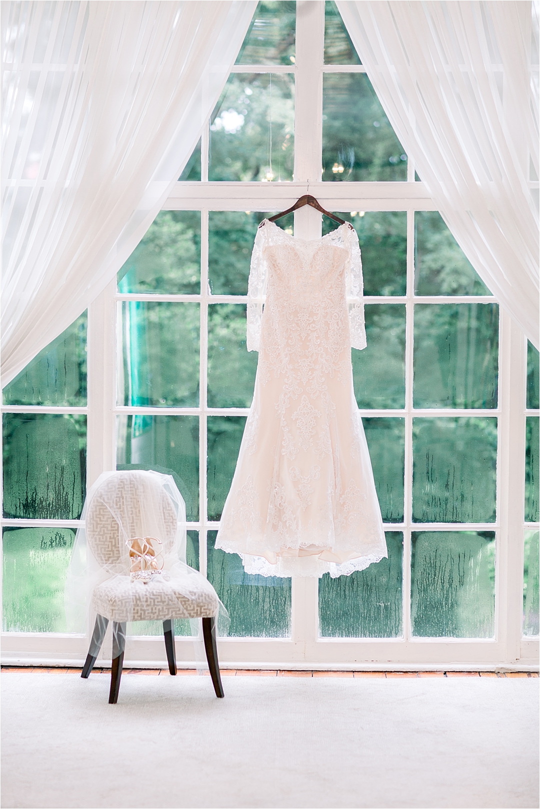 lace wedding gown hanging in window_Photos by Leigh Wolfe, Atlanta's Top Wedding Photographer
