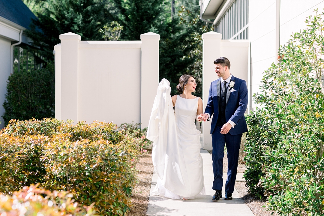 bride and groom walking through garden_Couples wedding portraits_Photos by Leigh Wolfe, Atlanta's top wedding photographer