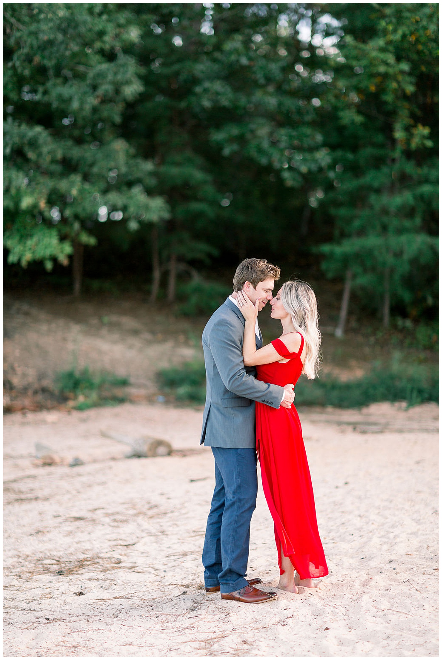 Engaged couple embracing on the shore at Lake Lanier in Georgia. 